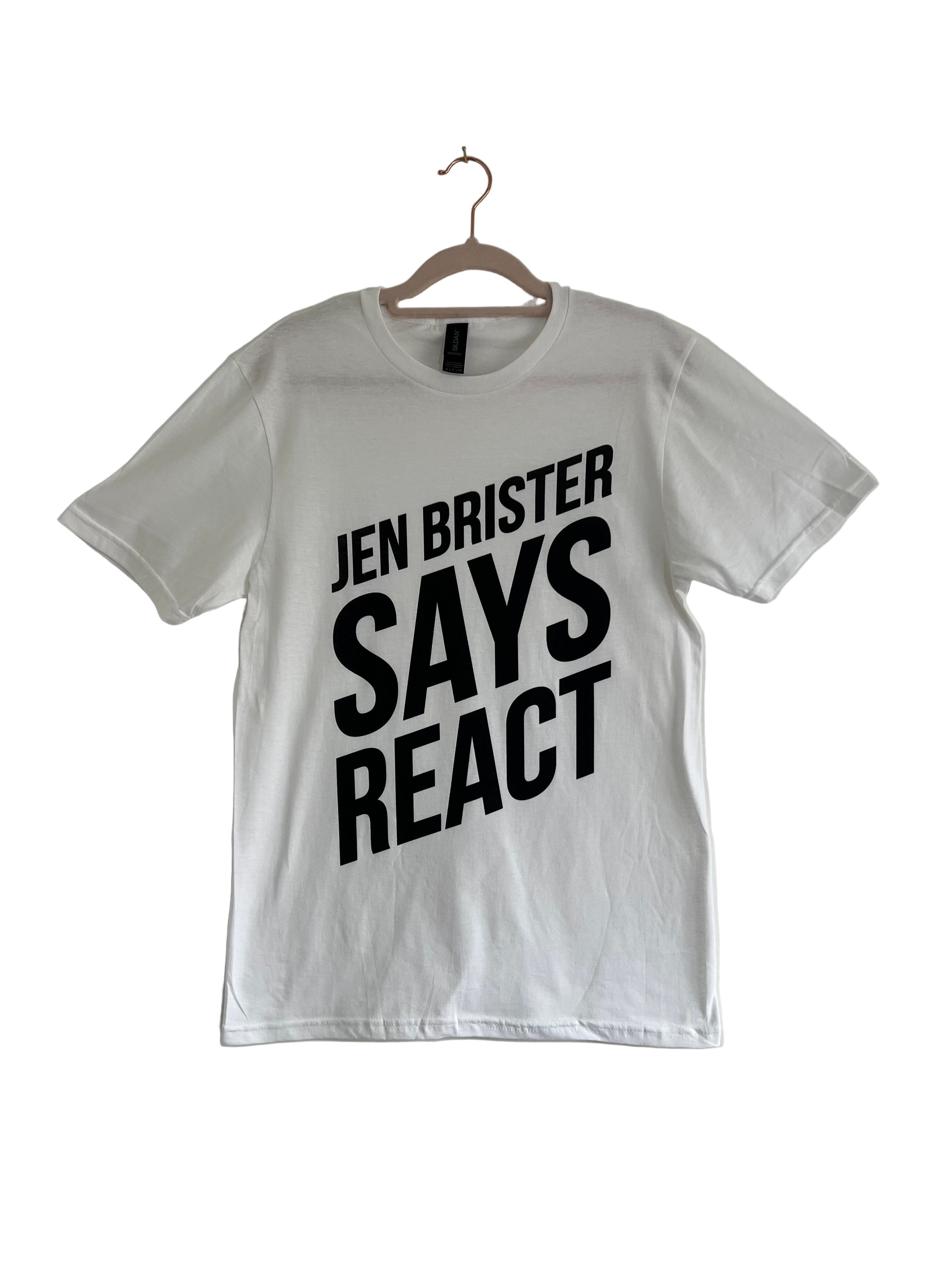 White t-shirt with 'JEN BRISTER SAYS REACT' text on a hanger against a plain background